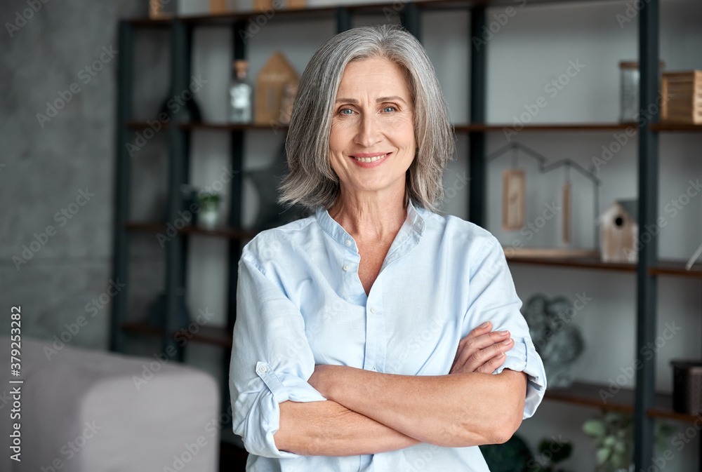 smiling-confident-stylish-mature-middle-aged-woman-standing-at-home-office-old-senior-businesswoman-60s-gray-haired-lady-executive-business-leader-manager-looking-at-camera-arms-crossed-portrait-stockpack-adobe-stock Smiling confident stylish mature middle aged woman standing at home office. Old senior businesswoman, 60s gray-haired lady executive business leader manager looking at camera arms crossed, portrait.